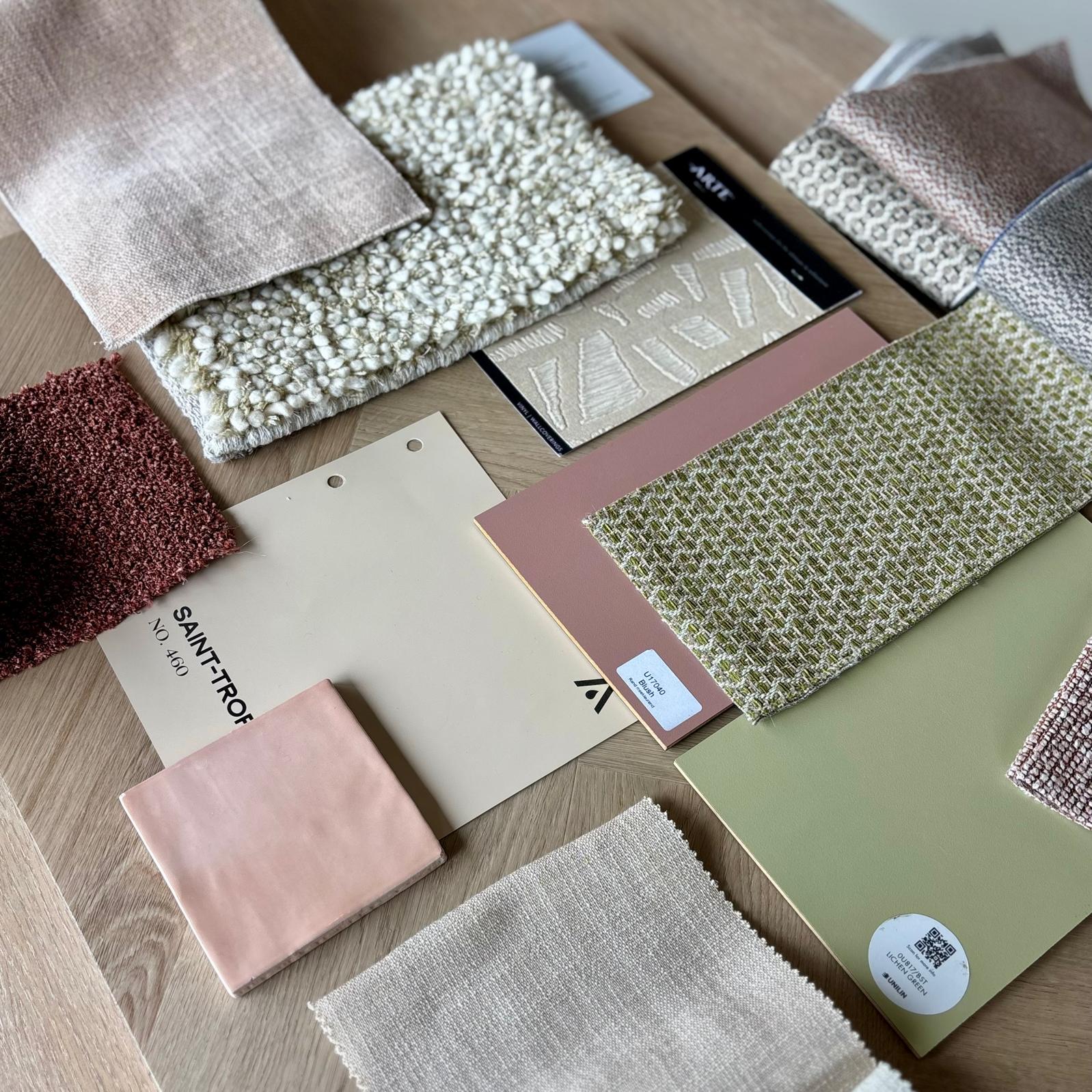 Materiaalstalen in zachte tinten op een houten tafel